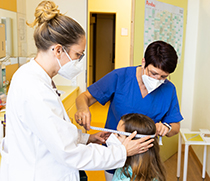 Oberärztin Dr. Katja Palm misst den Kopfumfang der 9-jährigen Kleinwuchspatientin Alina.